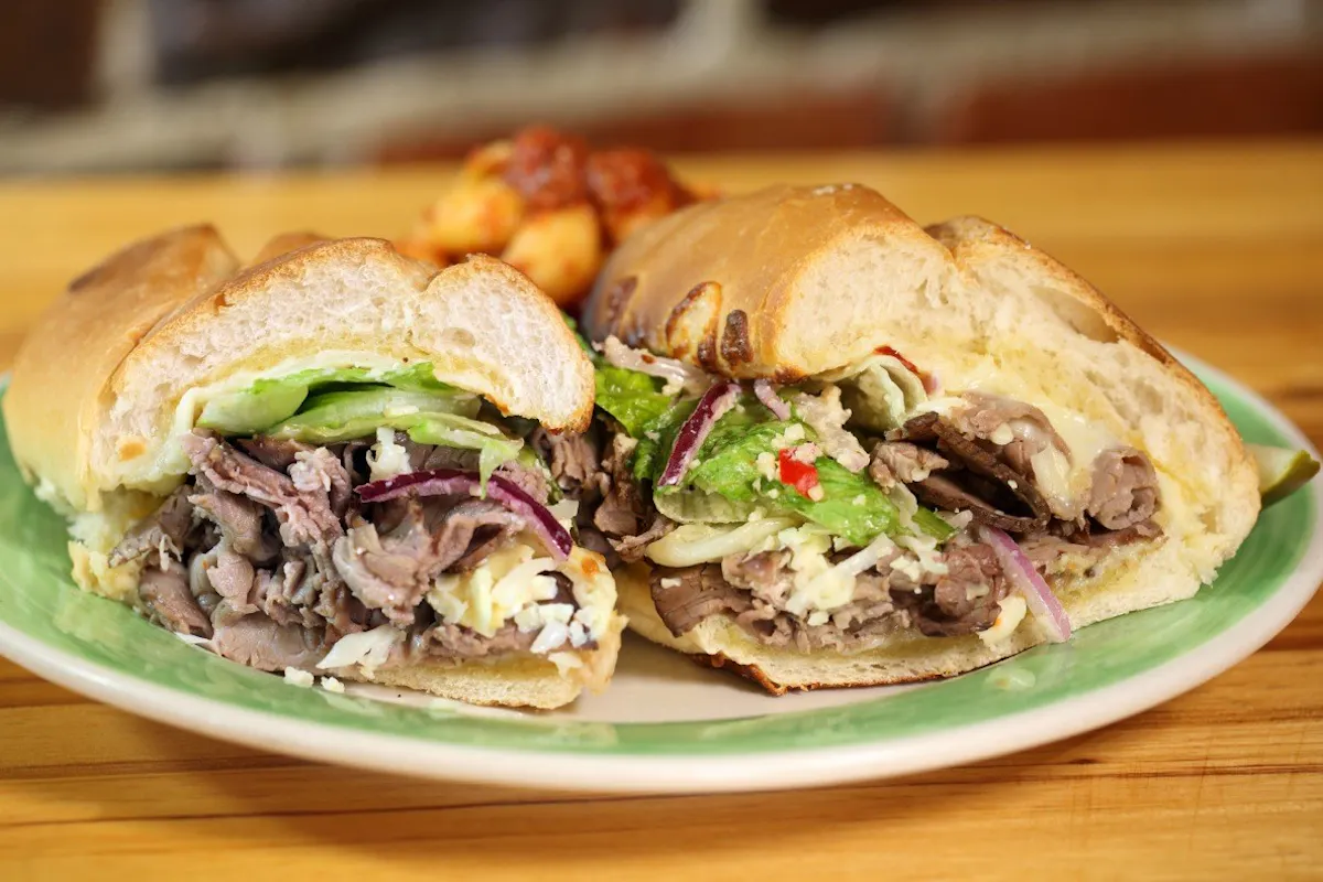 a closeup of two sandwiches sitting on a white table